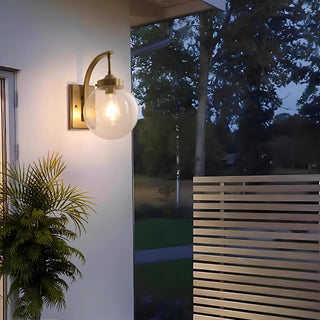 Luxury villa exterior with modern gold outdoor wall sconce lighting the entrance at night