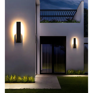 Wall sconces on modern villa facade glowing at night