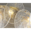Close-up of textured Murano glass discs on Virella luxury chandelier with warm ambient lighting