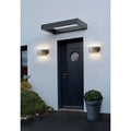 Pair of grey microcement lights framing entrance, casting warm symmetrical light
