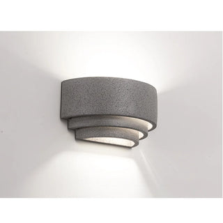 Warm light casting soft up-and-down glow from textured grey Wabi-Sabi sconce
