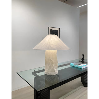 Wabi-sabi paper table lamp with sculptural textured base and wide shade placed on a modern glass console table