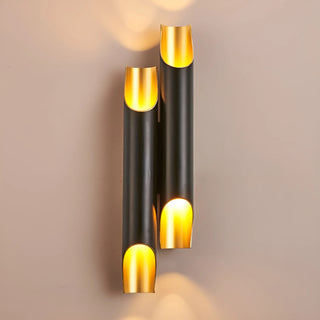 Twin black and gold modern wall lights with warm glow on beige wall