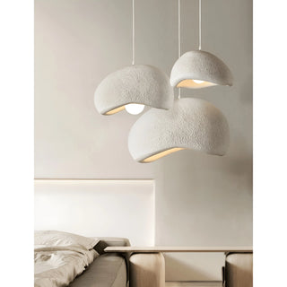 cluster of sculptural white wabi-sabi pendant lights illuminating a serene minimalist bedroom with neutral walls and modern furniture