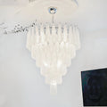 White tiered textured glass chandelier suspended in a contemporary minimalist interior